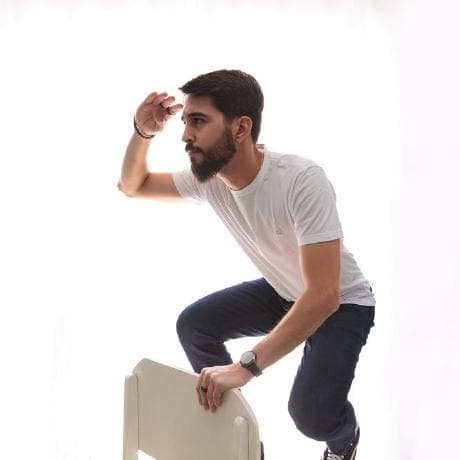 A man with a white t-shirt looking to the horizon.